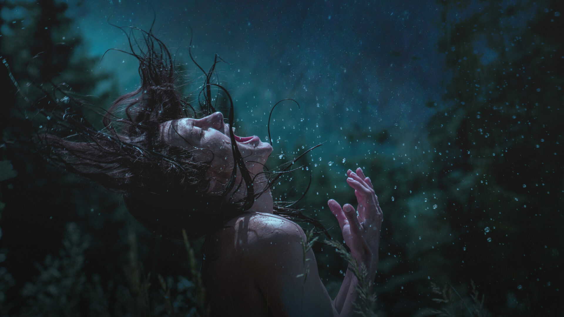 Zdjęcie; Las nocą; naga kobieta z ciemnymi, mokrymi włosami krzyczy w stronę nieba