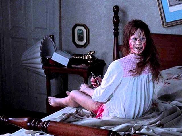 Zdjęcie; Dziewczynka z głową obróconą o 180 stopni, ubrudzona krwią siedzi na łóżku i uśmiecha się